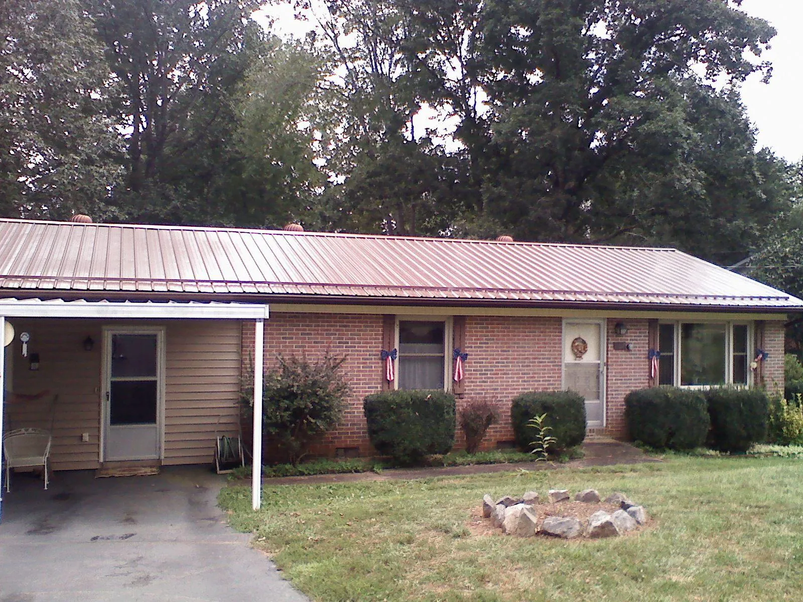 Bronze metal roof and carport on a brick ranch home — Roof Repair work by our crew in Mascot